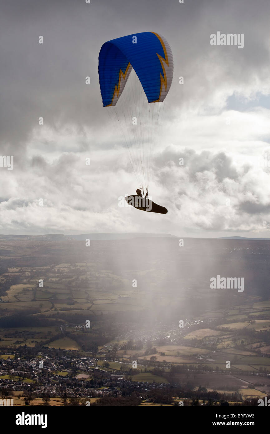 Une personne est suspendue à un parachute parapente-like et flotte dans l'air sur le Sud du Pays de Galles. Banque D'Images