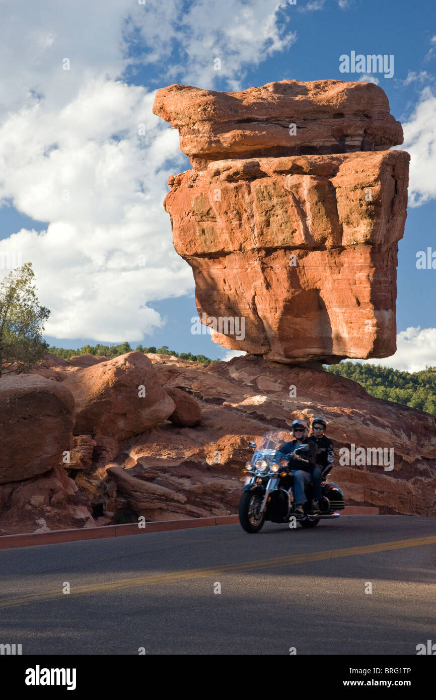 Couple sur un tour de moto passé Balanced Rock, le Jardin des Dieux, National Natural Landmark, Colorado Springs, Colorado, États-Unis Banque D'Images