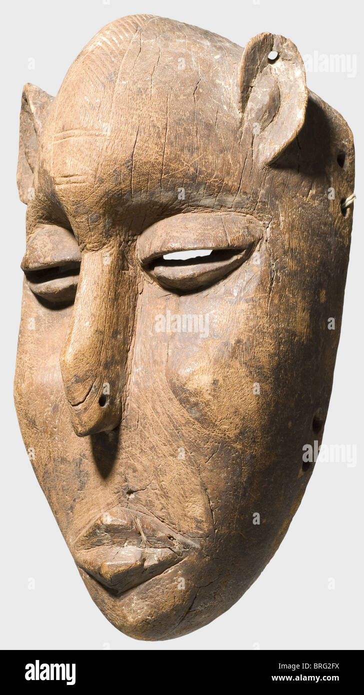 Un masque de Bambara, Mali, 1ère moitié du 20ème siècle. Un masque en bois zoomorphe avec des yeux fendus, une bouche en forme de diamant et des oreilles pointues et perforées. Décoration géométrique rayée sur le front. Trous de fixation sur les bords pour la décoration en fibres textiles. La surface a de la patine dans des endroits, un peu fissurés, avec des marques d'utilisation. Hauteur 31 cm. Historique,historique,beaux-arts,art,tribu,tribus,tribal,africaine,Afrique,ethnique,ethnicités,ethnologie,ethnicité,ethnique,exotique,Wodden,sculpture,sculptures,figure,figures,objet,objets,alambics,clippi,droits additionnels-Clearences-non disponible Banque D'Images