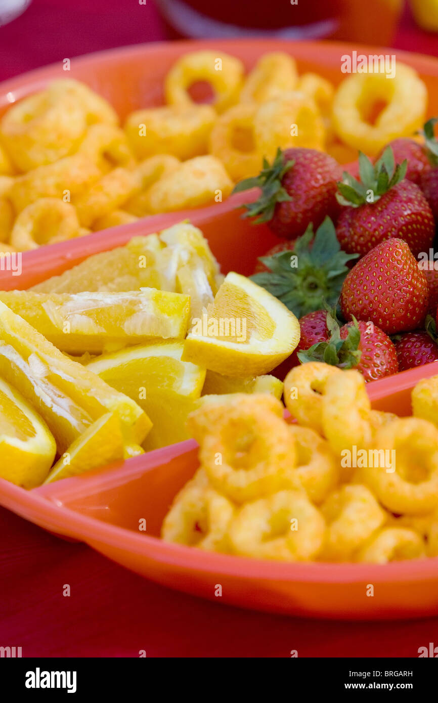 Close-up de fraises, de tranches de citron et fromage boucles dans un bol divisé. Format vertical. Banque D'Images