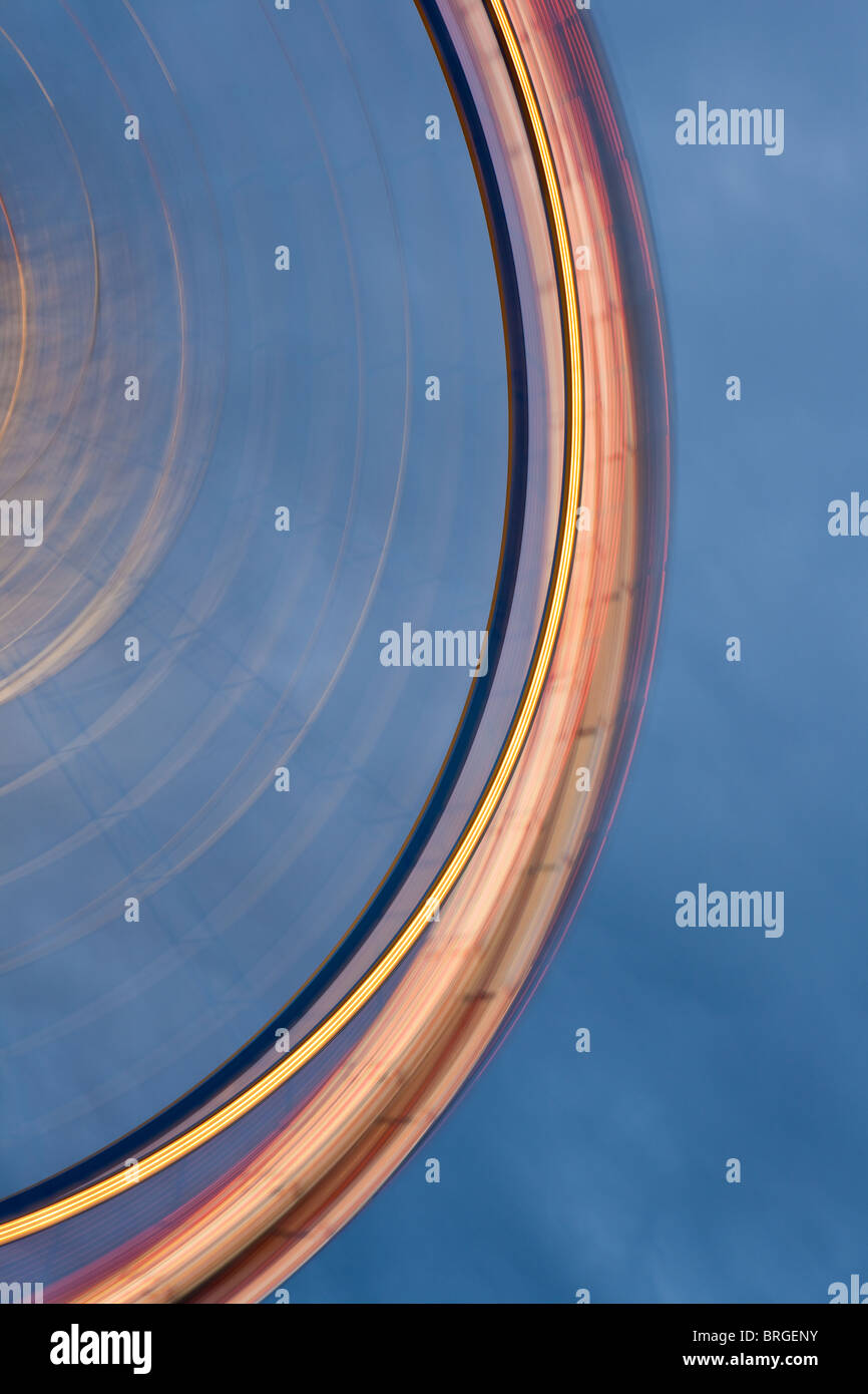 Grande roue avec le flou d'allumé jusqu'au crépuscule à l'Oktoberfest, Munich Banque D'Images