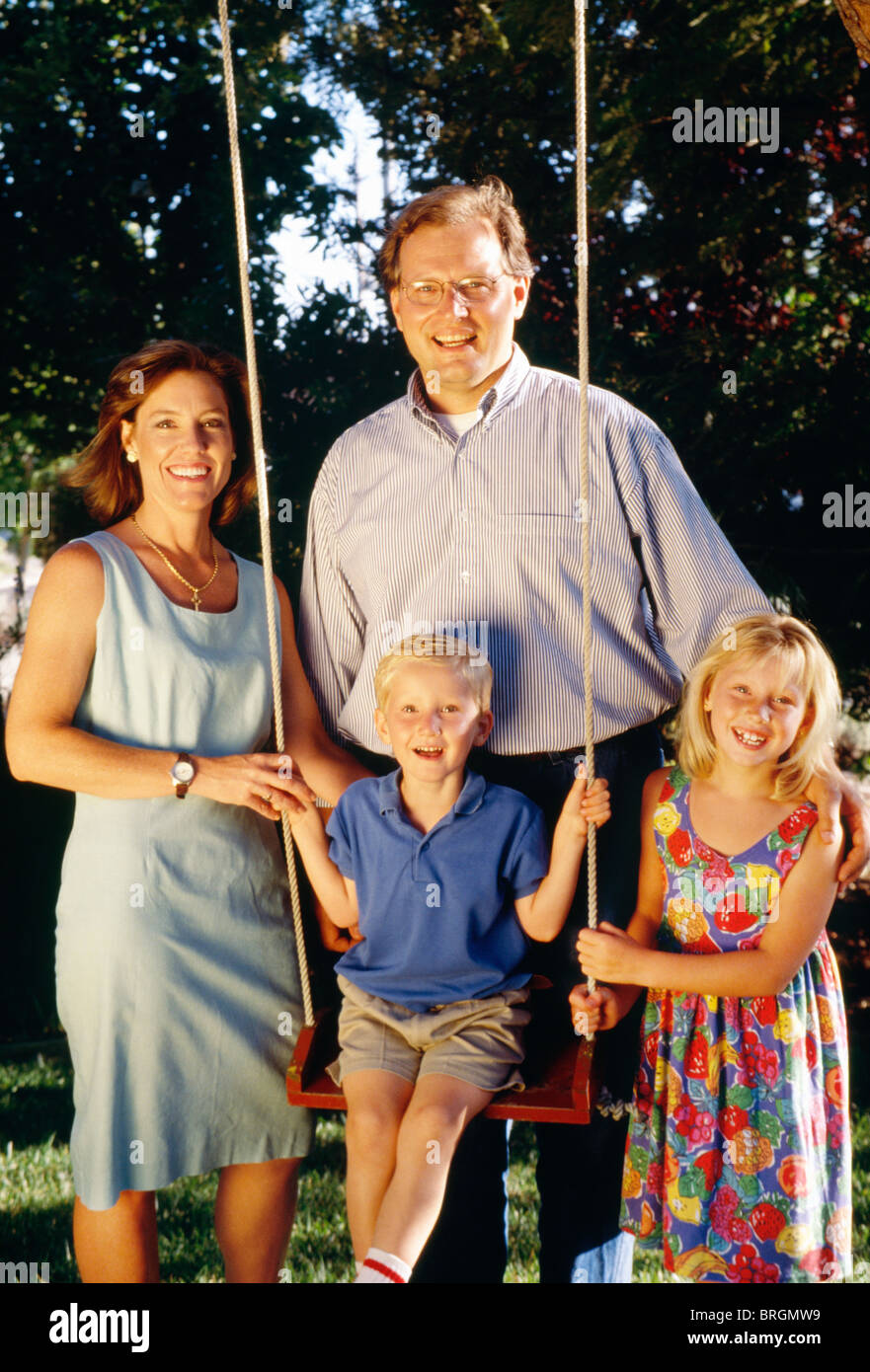 Famille de quatre Smiling at Camera In Backyard Banque D'Images