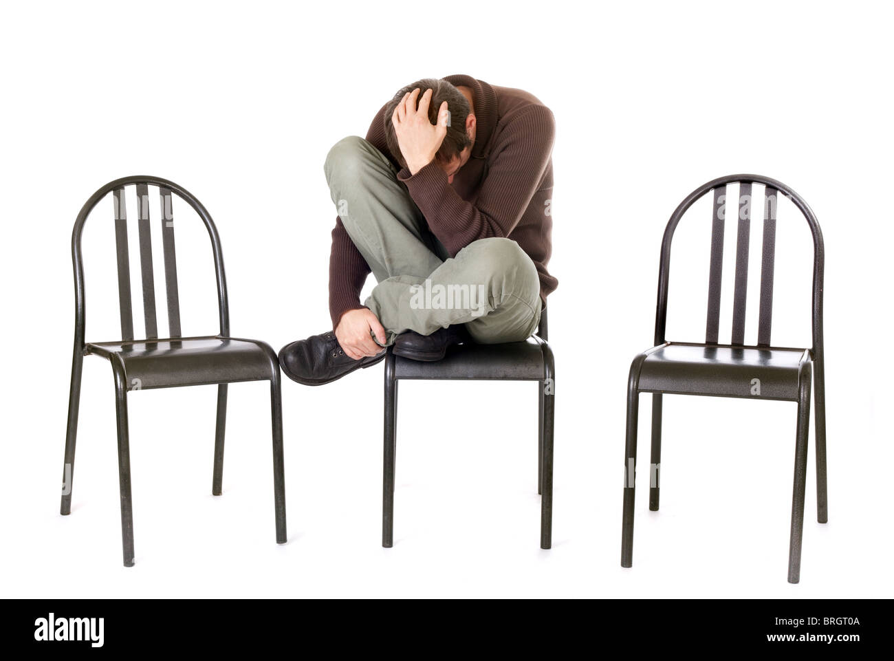 Triste et seul man sitting on chair isolated on white Banque D'Images