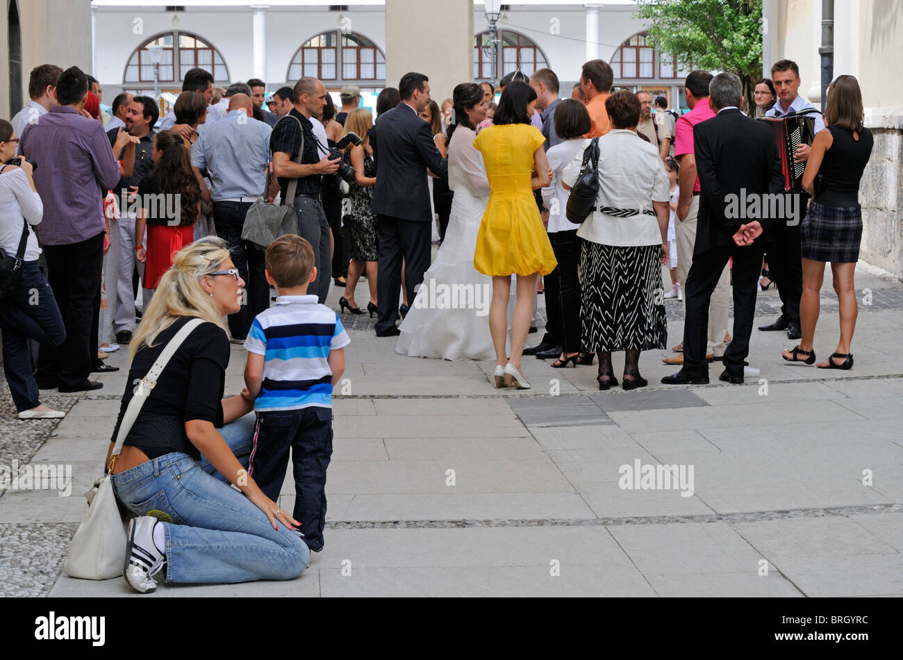 Ljubljana, Slovénie. La mère et le fils en regardant les invités du mariage de l'église de l'extérieur Banque D'Images