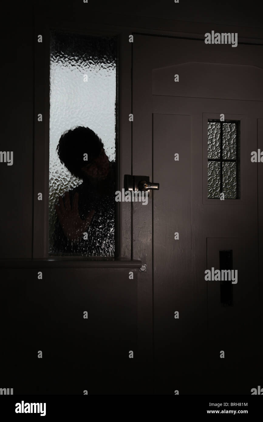 D'un homme Silhoette peeping par glaas givré à côté de porte avant Banque D'Images