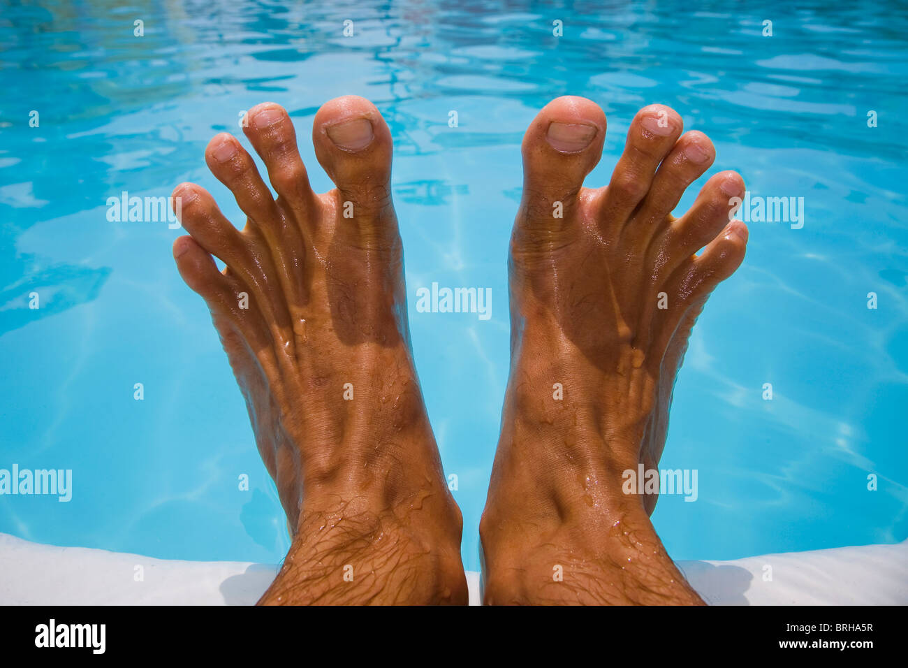 Les pieds d'un homme d'une piscine bleu Banque D'Images