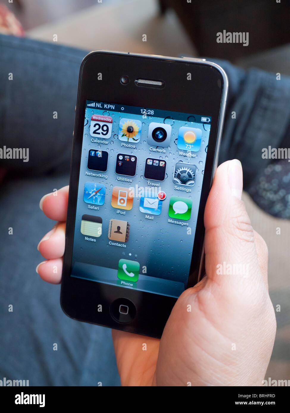 Femme tenant l'iPhone 4G Téléphone intelligent sur l'écran d'accueil Banque D'Images