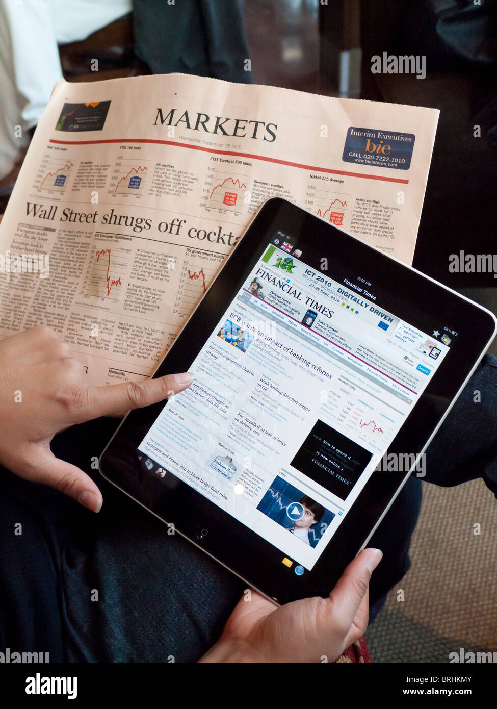 Femme à l'aide de l'ordinateur tablette iPad pour consulter les cours de la bourse en ligne du journal Financial Times Banque D'Images