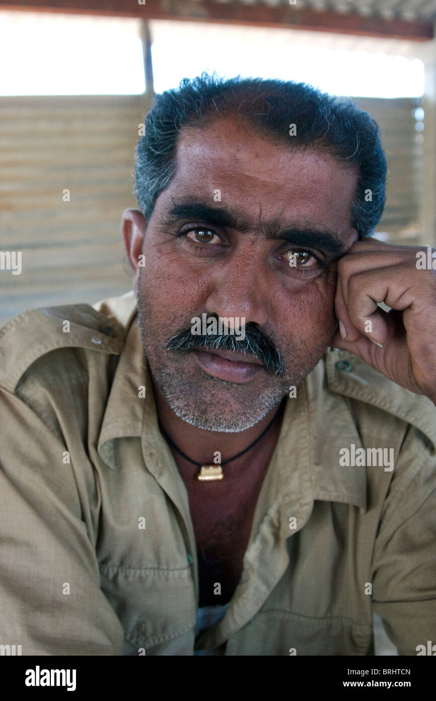 Bus-Driver ressemble attentivement tout en tenant l'appareil photo à son travail-rupture de l'État du Gujarat, en Inde. Banque D'Images