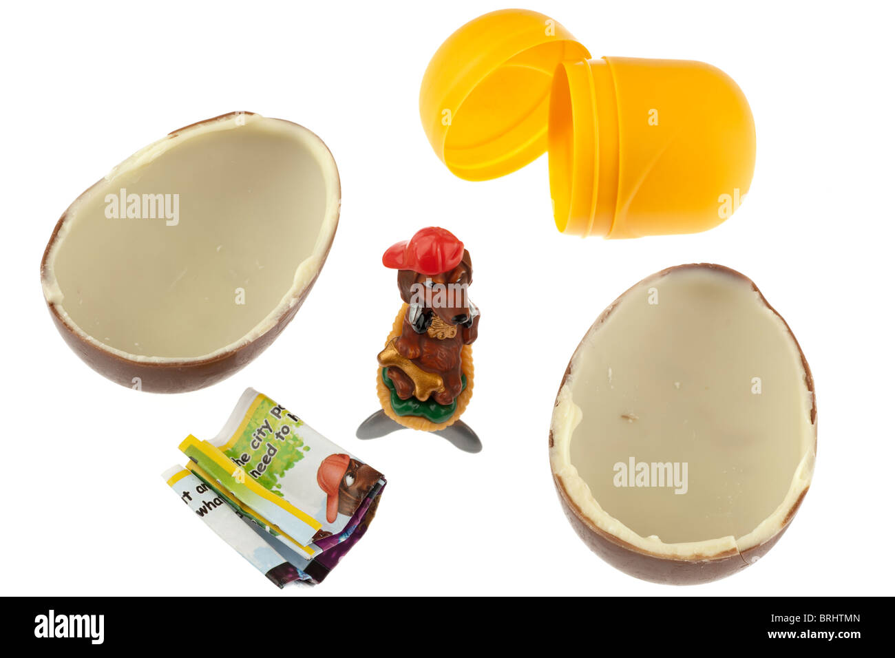 Oeuf en chocolat Kinder Surprise déballés et divisé en deux moitiés avec toy et contenant en plastique Banque D'Images