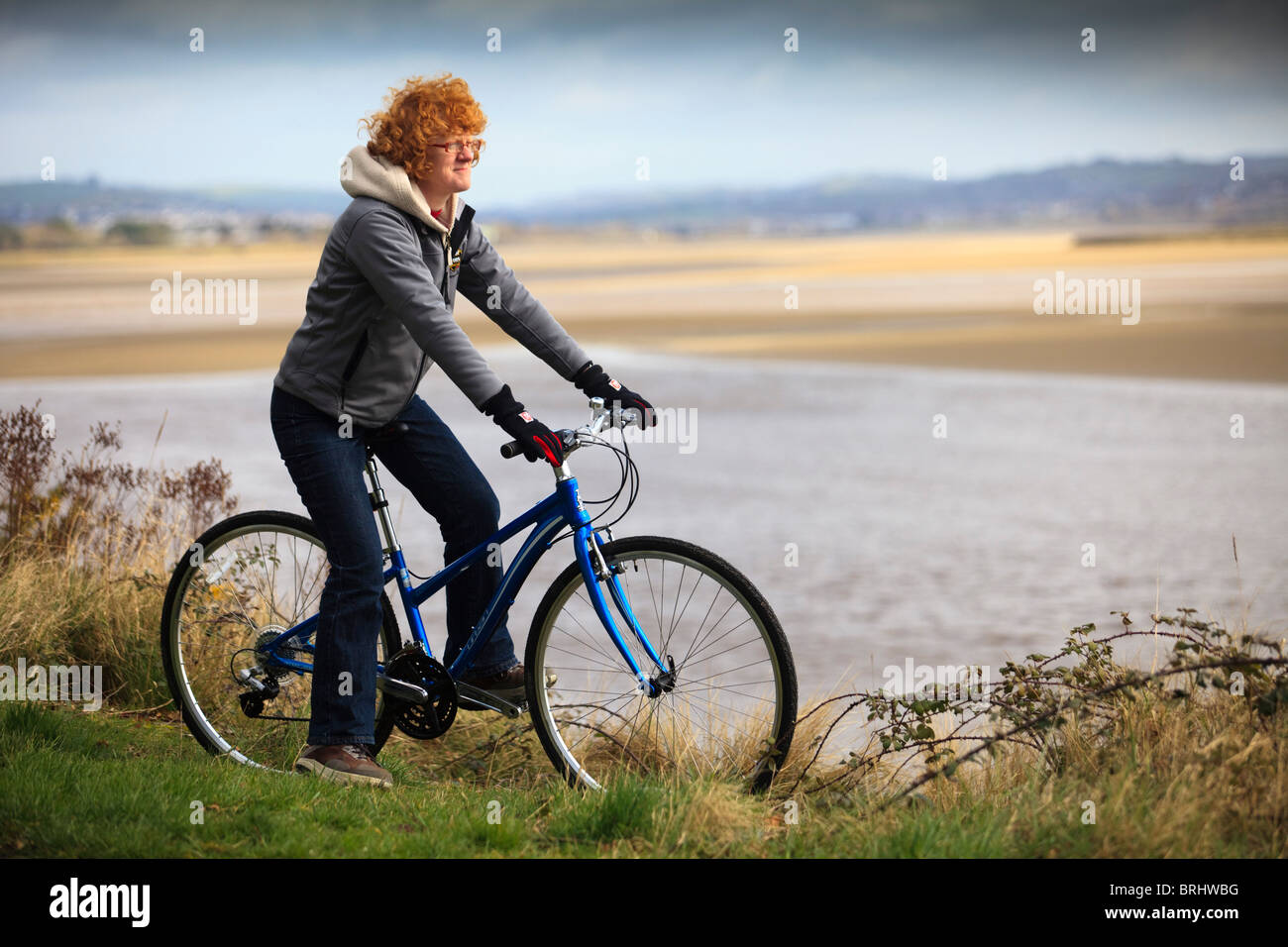 Cycliste féminine à la vue à de l'estuaire sur le Tarka Trail National Cycle Route 27 à Ilfracombe, Devon, UK Banque D'Images
