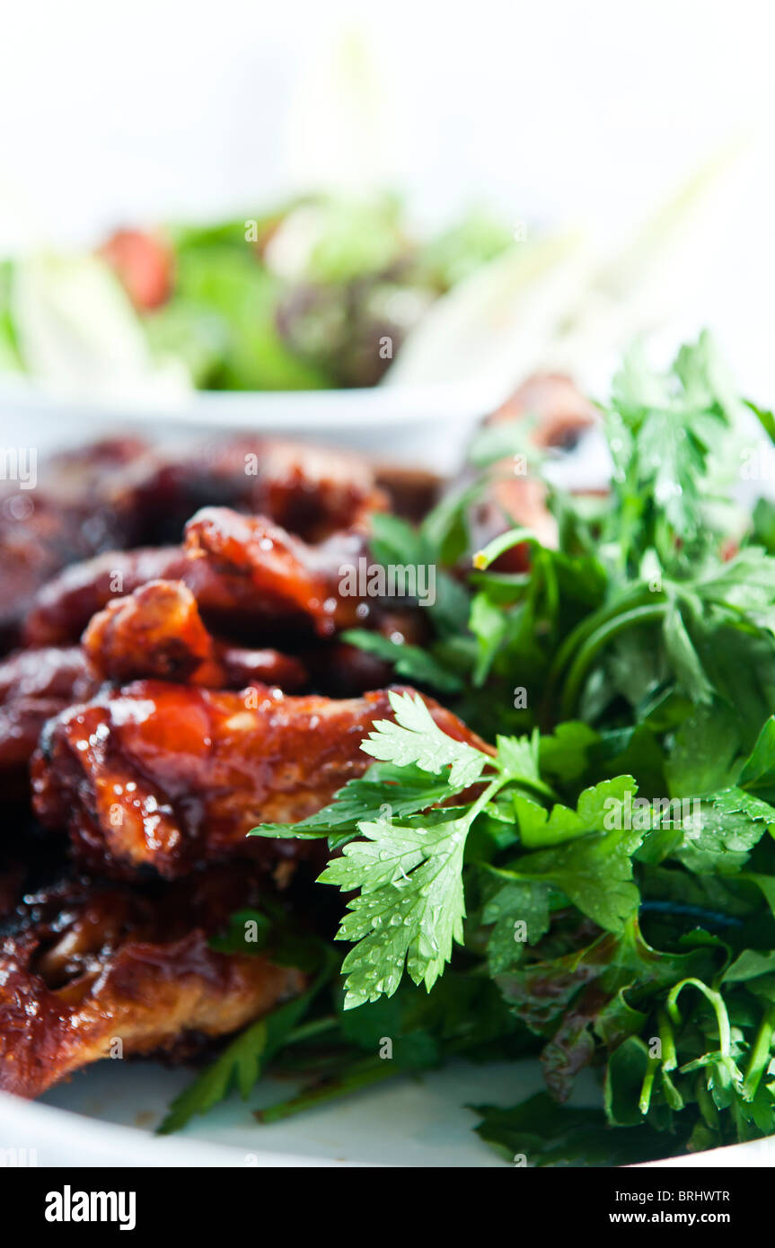 Close up of BBQ Ribs et poulet avec une salade verte Banque D'Images