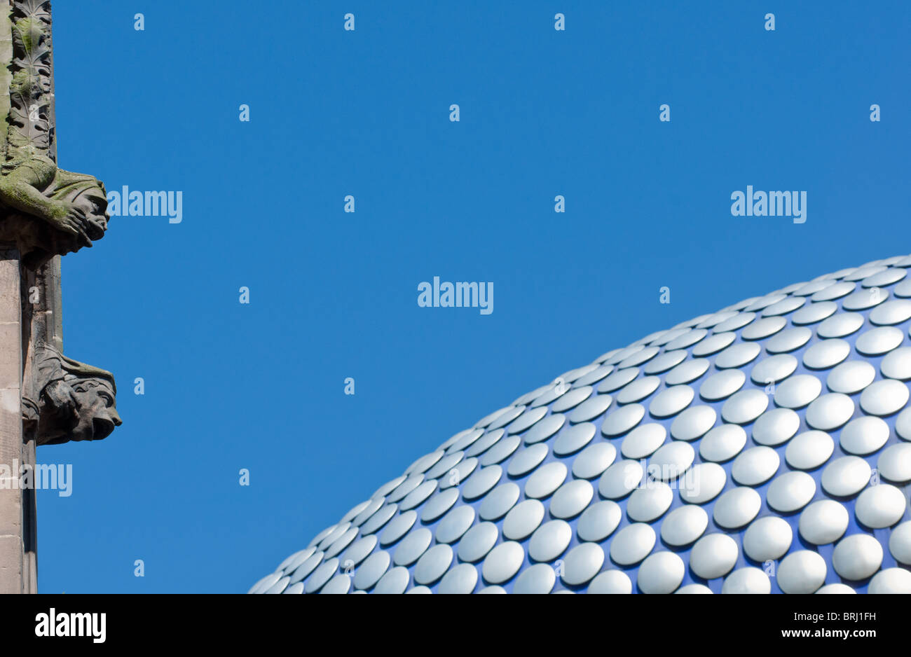 L'image contrastée de l'immeuble ultra moderne Selfridges à Birmingham, Royaume-Uni, avec l'ancien gargouilles sur l'église St Martin. Banque D'Images