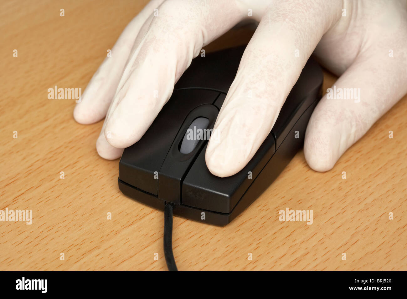 port à la main de gants en caoutchouc chirurgical sur une souris d'ordinateur protégeant contre l'infection ou le concept de sécurité Banque D'Images