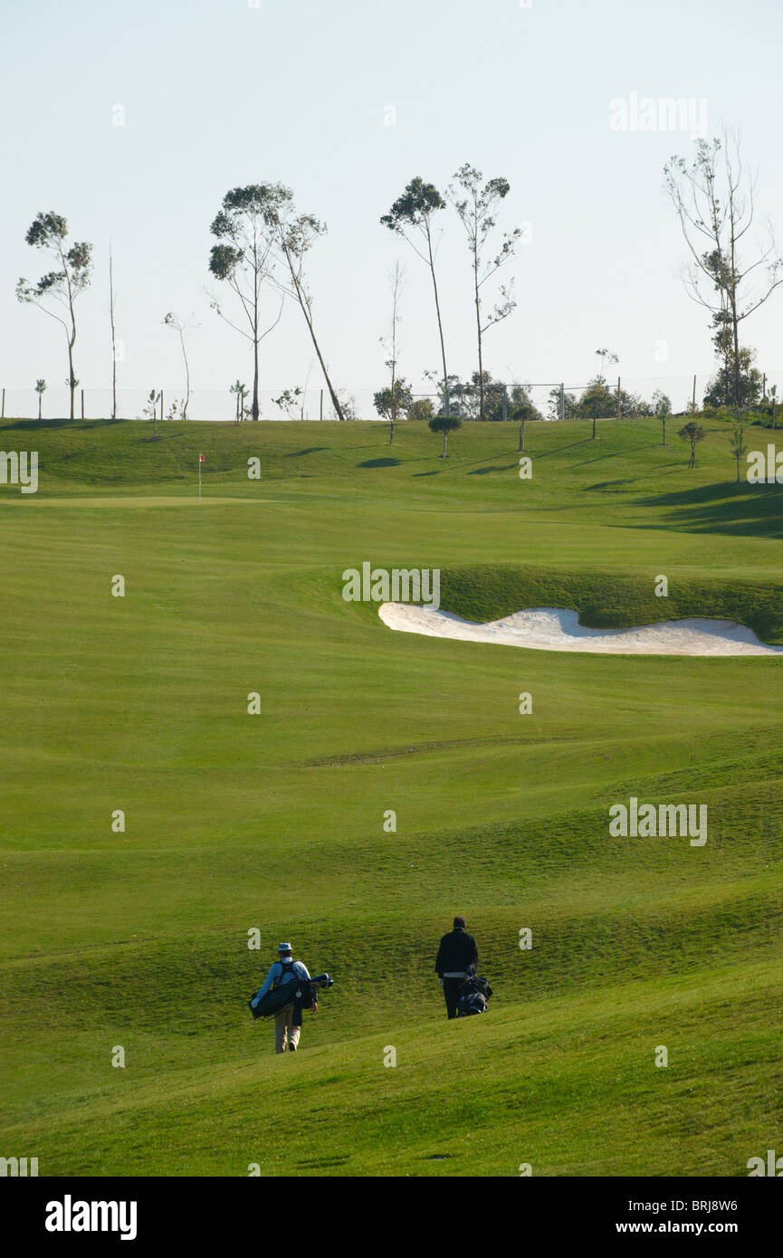 Deux hommes à pied avec matériel de golf d'un terrain de golf au Portugal Banque D'Images