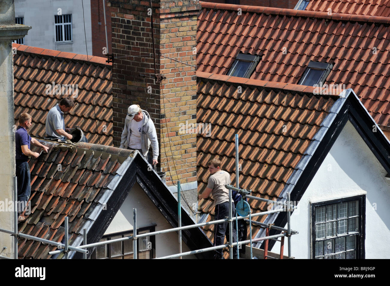 Builders remplacement tuiles faîtières sur le toit, d'une rénovation, UK Banque D'Images