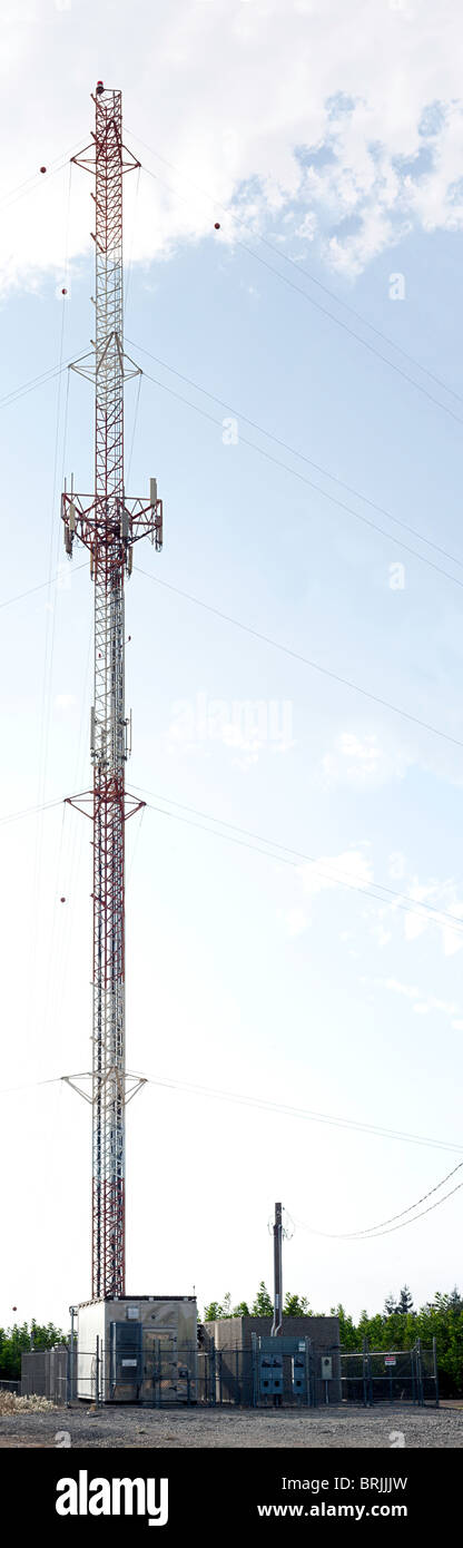 Une photo panoramique d'une antenne de téléphone cellulaire tour et des bâtiments connexes Banque D'Images