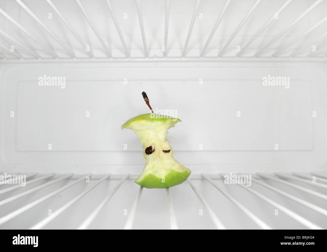 Seul apple core assis sur une étagère à l'intérieur de réfrigérateur Banque D'Images