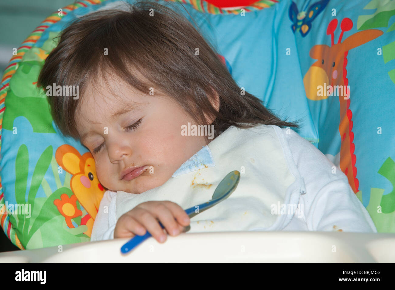 Dormir dans une chaise haute bébé Banque D'Images