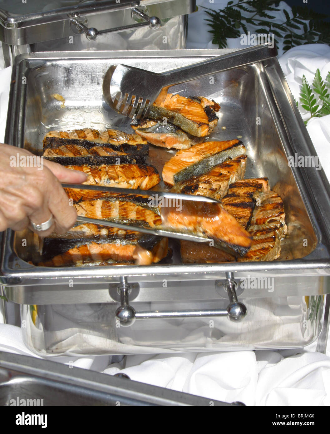 Délicieux et fraîchement darnes de saumon grillées servi de réchauffement en acier inoxydable serveurs sur un navire de croisière de luxe. Servir tong Banque D'Images