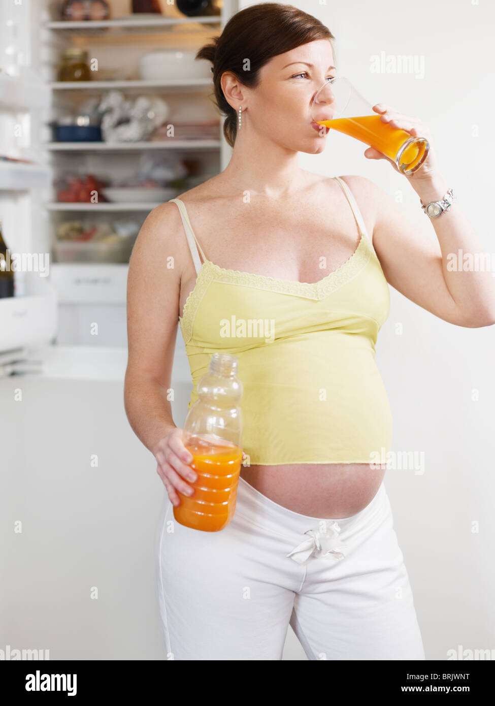 Pregnant woman drinking orange juice Banque D'Images