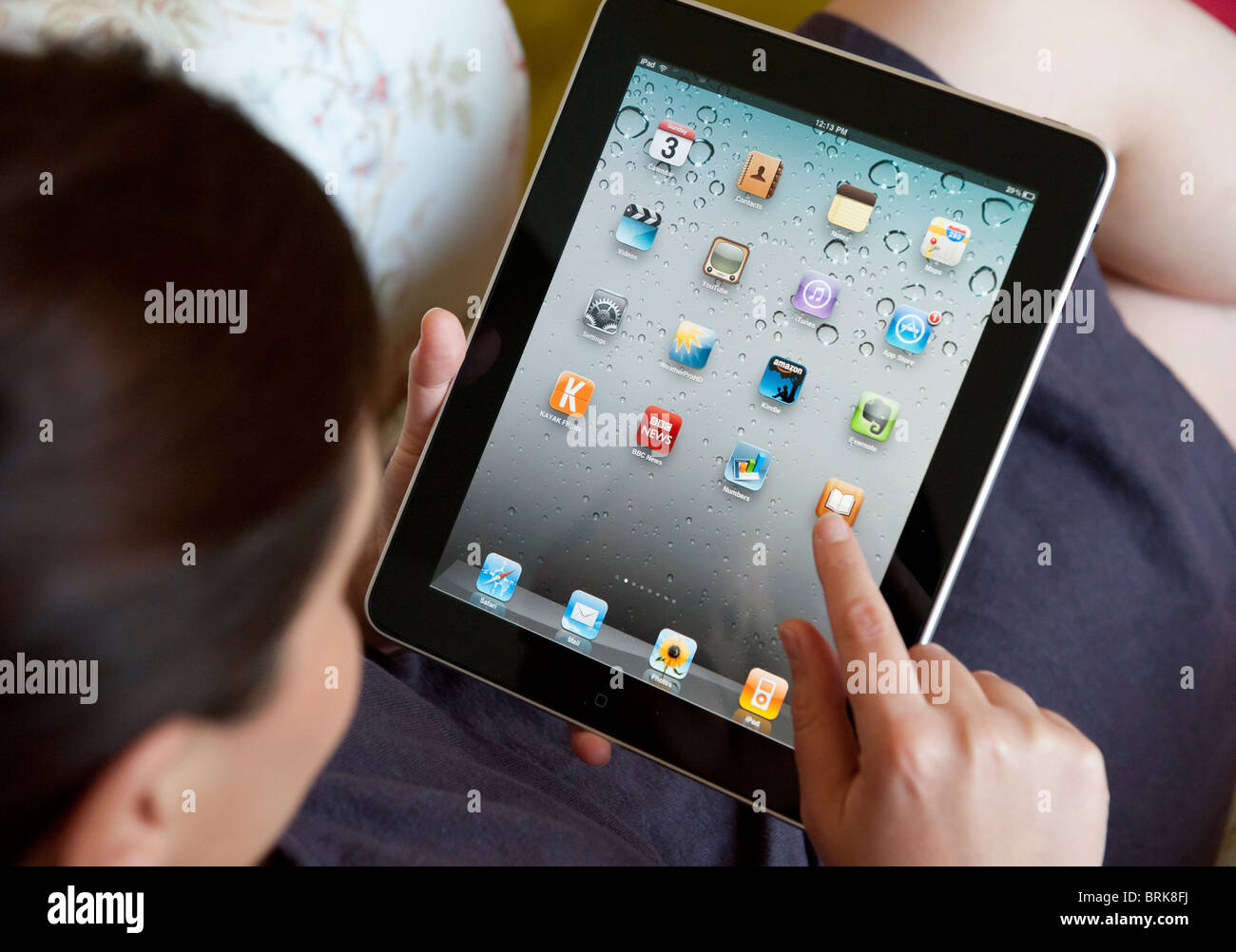 Woman holding et l'utilisation d'un ordinateur tablette iPad pour télécharger des applications sur le wifi à la maison Banque D'Images
