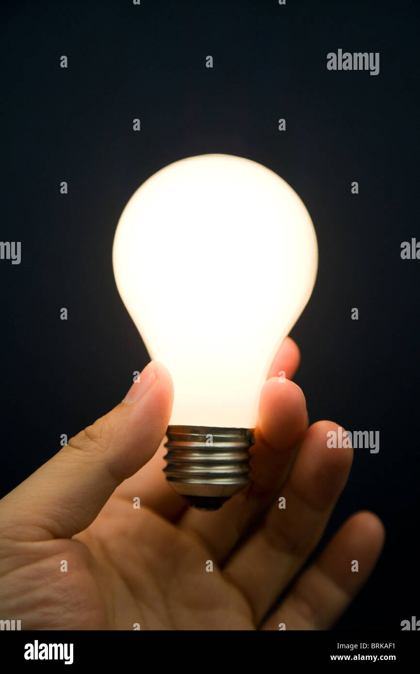 Main tenant une ampoule lumineuse, concept d'inspiration, des idées Banque D'Images
