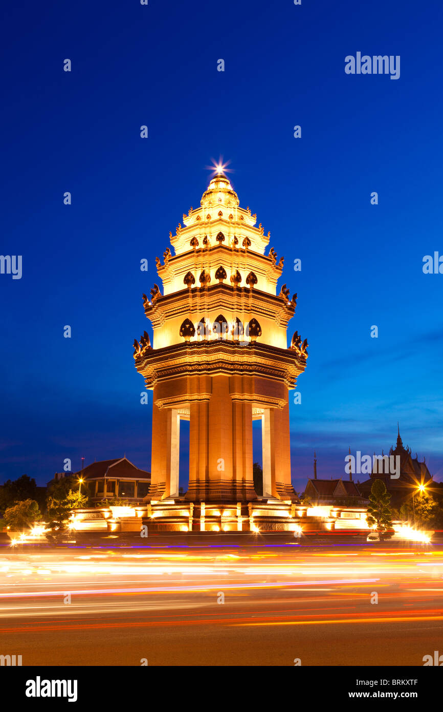 Le Monument de l'indépendance à Phnom Penh à la tombée de la nuit avec le trafic - Phnom Penh, Cambodge Banque D'Images