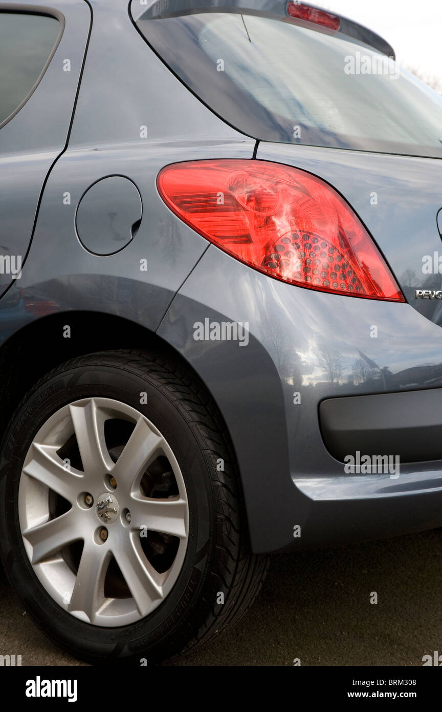 Vue rapprochée de la lumière arrière et pare-chocs en plastique sur une voiture Peugeot. Banque D'Images