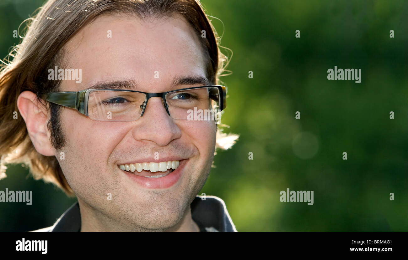 Smiling man en plein air avec fond naturel vert Banque D'Images