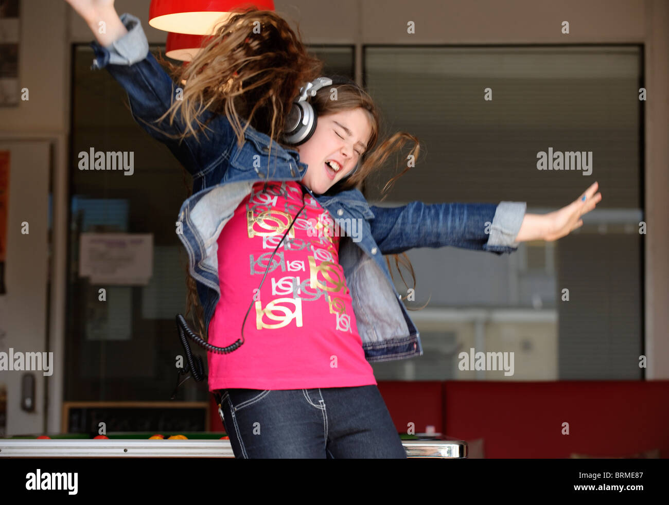 Jumping Girl wearing headphones Banque D'Images