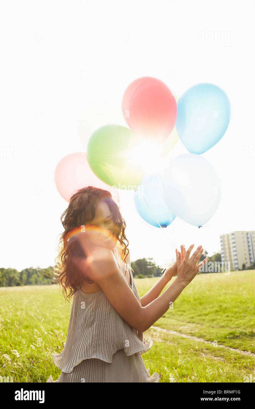 Femme avec des ballons d'air dans les prés Banque D'Images