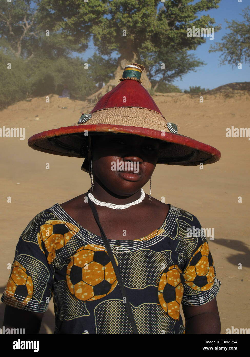 Une femme africaine portant un chapeau traditionnel qui est l'ombre ses  yeux et un chemisier qui a un modèle de football sur elle Photo Stock -  Alamy