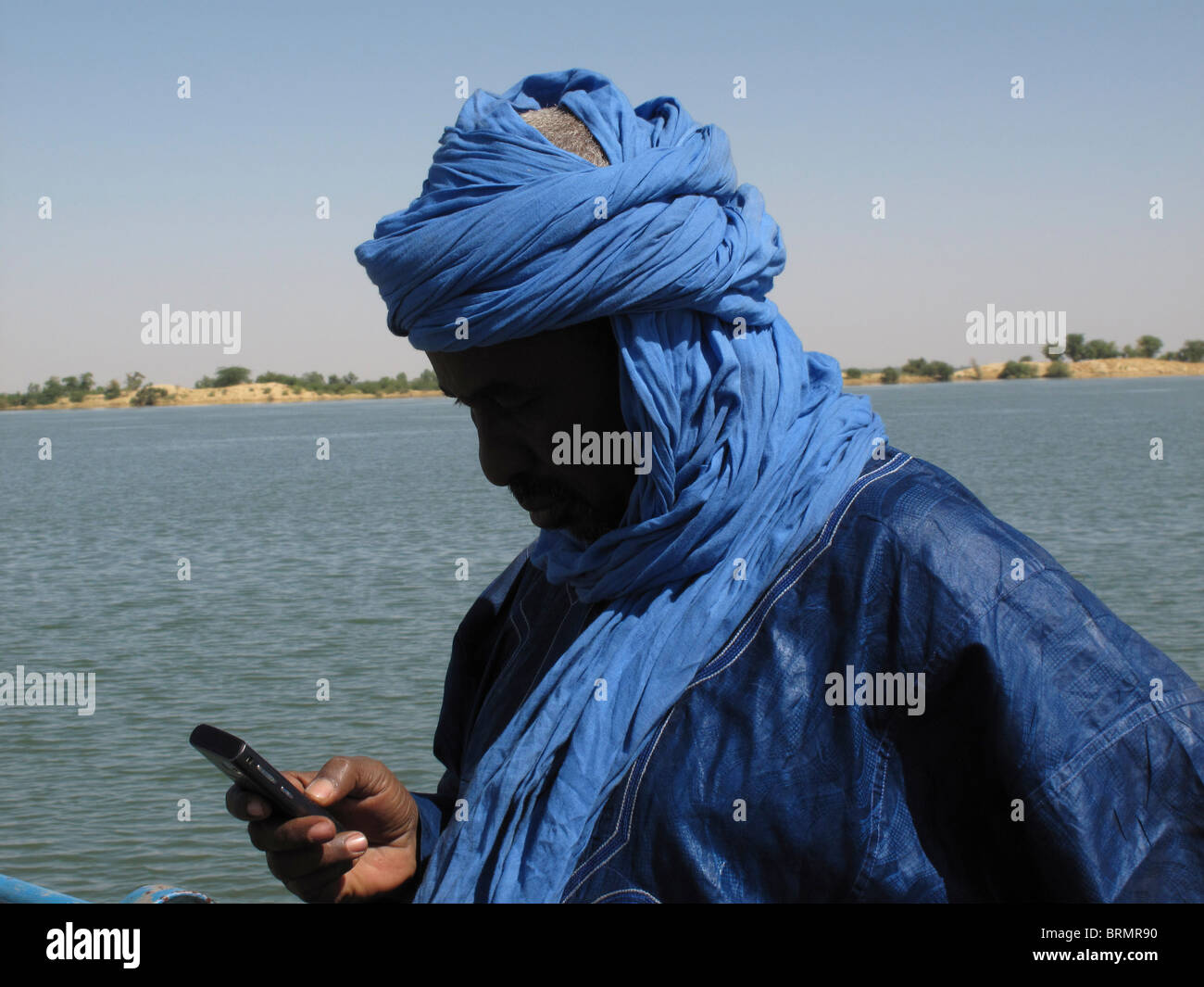 Homme touareg vêtus de robes bleu traditionnel à l'aide d'un téléphone cellulaire Banque D'Images
