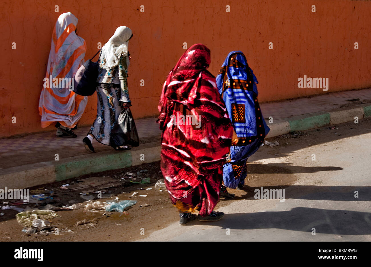 Les femmes marocaines en tenues traditionnelles colorées marchant le long d'une rue du village Banque D'Images
