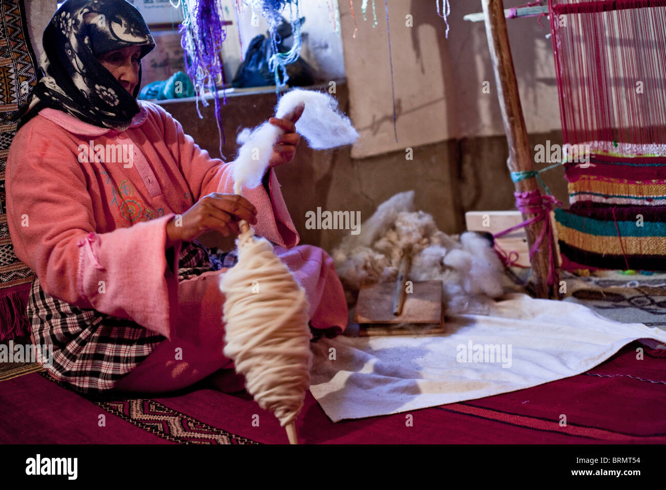 Une femme berbère prépare un lot de laine pour un tapis berbère Banque D'Images