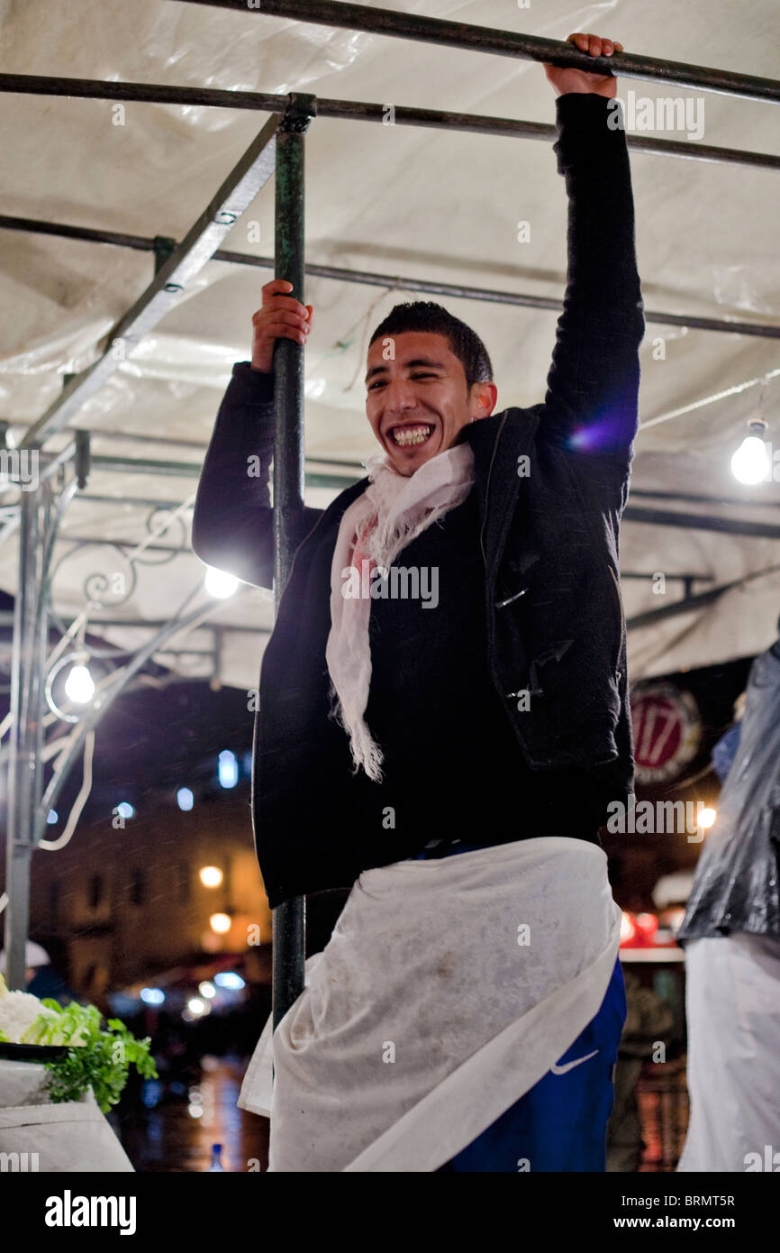 Un fournisseur marocain accroché à l'échafaudage de son échoppe de marché Banque D'Images