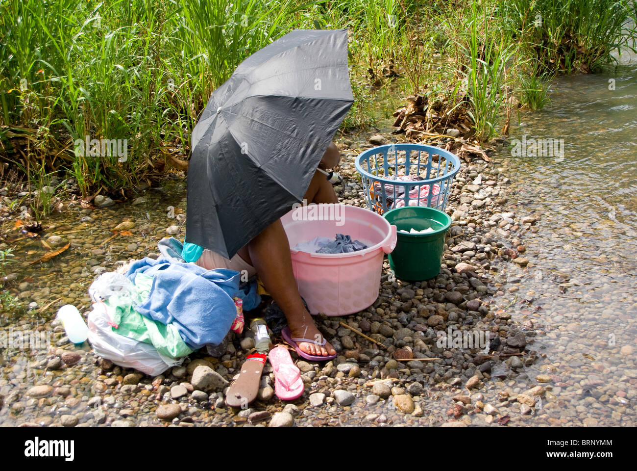 Humour - Femme avec parapluie rivière par lavage Banque D'Images