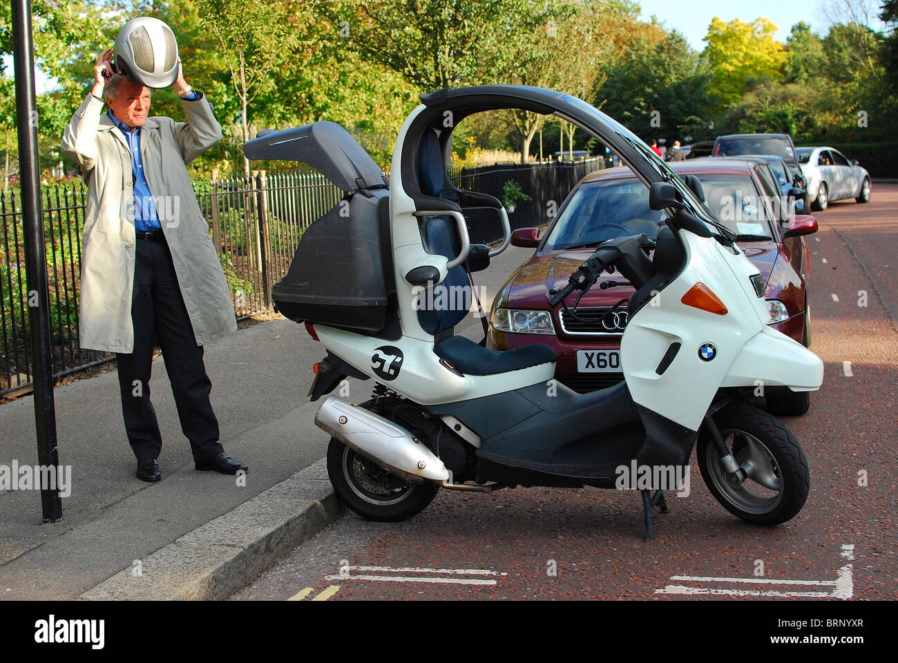 L'homme dépose son casque par cyclomoteur BMW à Londres Banque D'Images