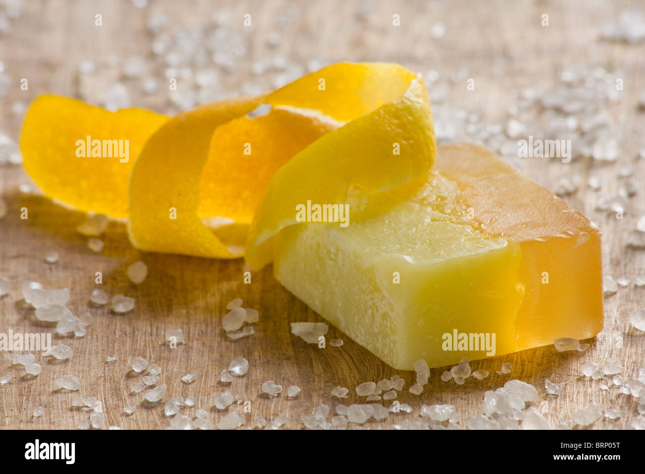 Savon parfumé au citron à la main sur fond de bois Banque D'Images