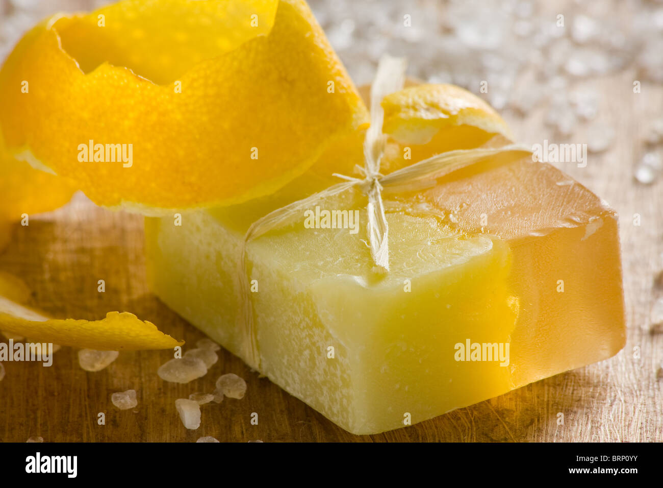 Savon parfumé au citron à la main sur fond de bois Banque D'Images