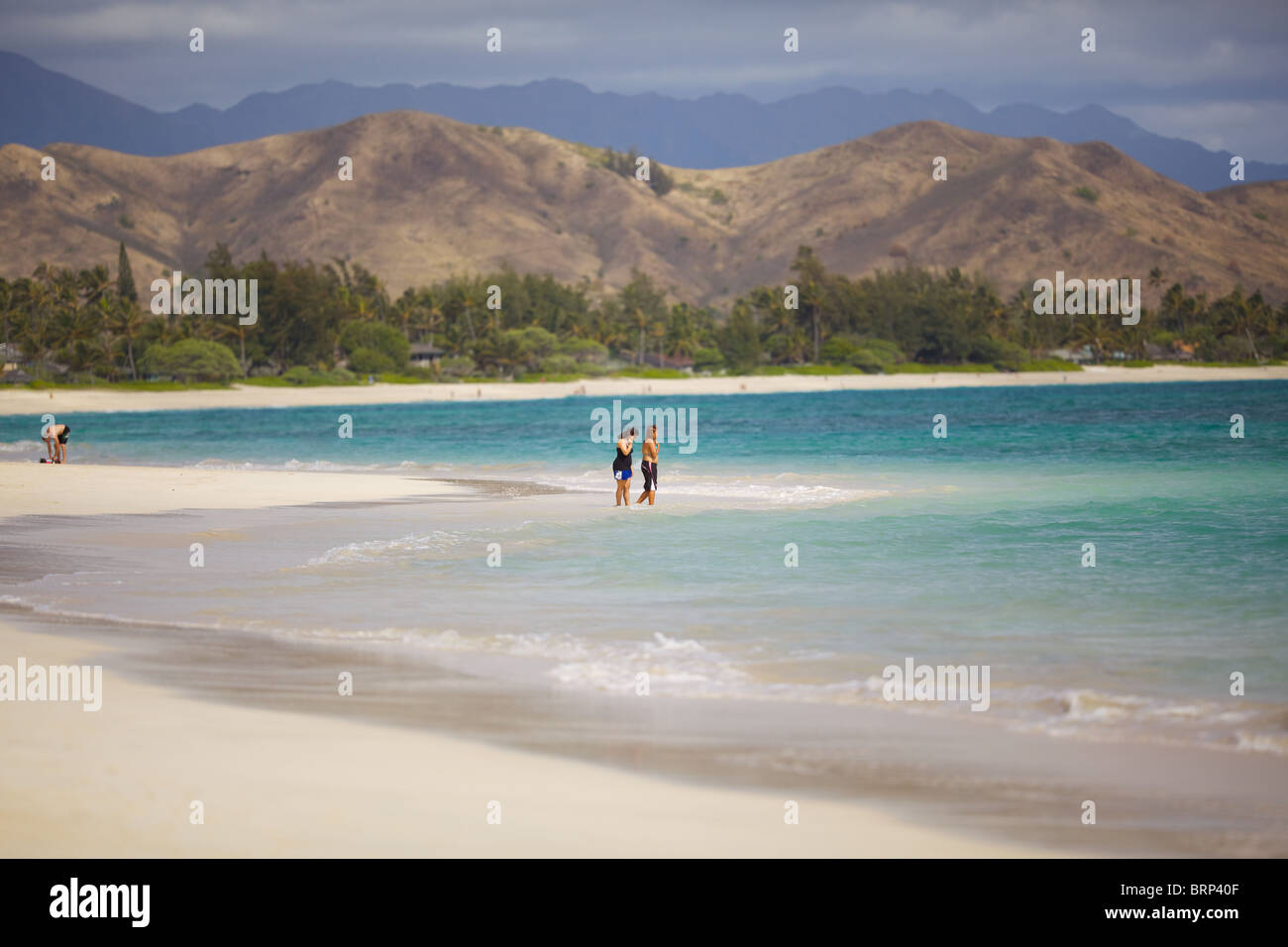 Deux personnes s'en tenir à la lisière de l'océan à Kailua Beach, Oahu, Hawaii Banque D'Images