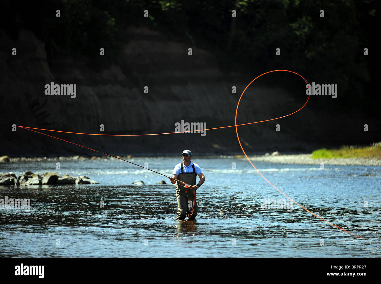 Un pêcheur de saumon se prépare à jeter une ligne dans un bon à la piscine sur un fleuve écossais Banque D'Images