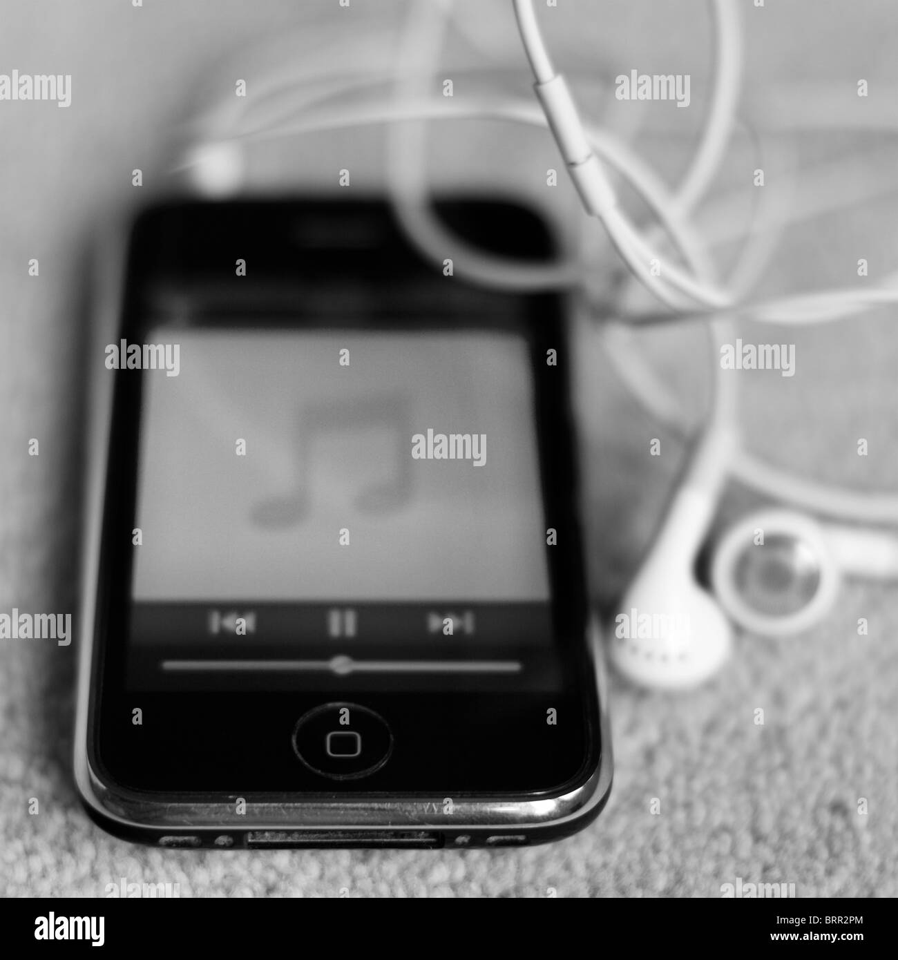 L'iPhone 3GS à jouer de la musique avec des écouteurs Banque D'Images