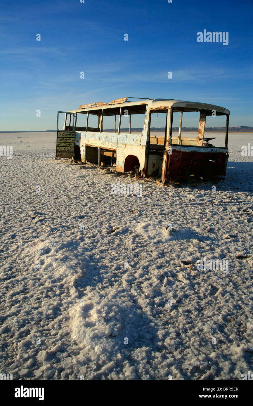 Un bus rouillé et cassé épave gît sur le lac salé de Chott el-Jerrid dans le sud de la Tunisie Banque D'Images