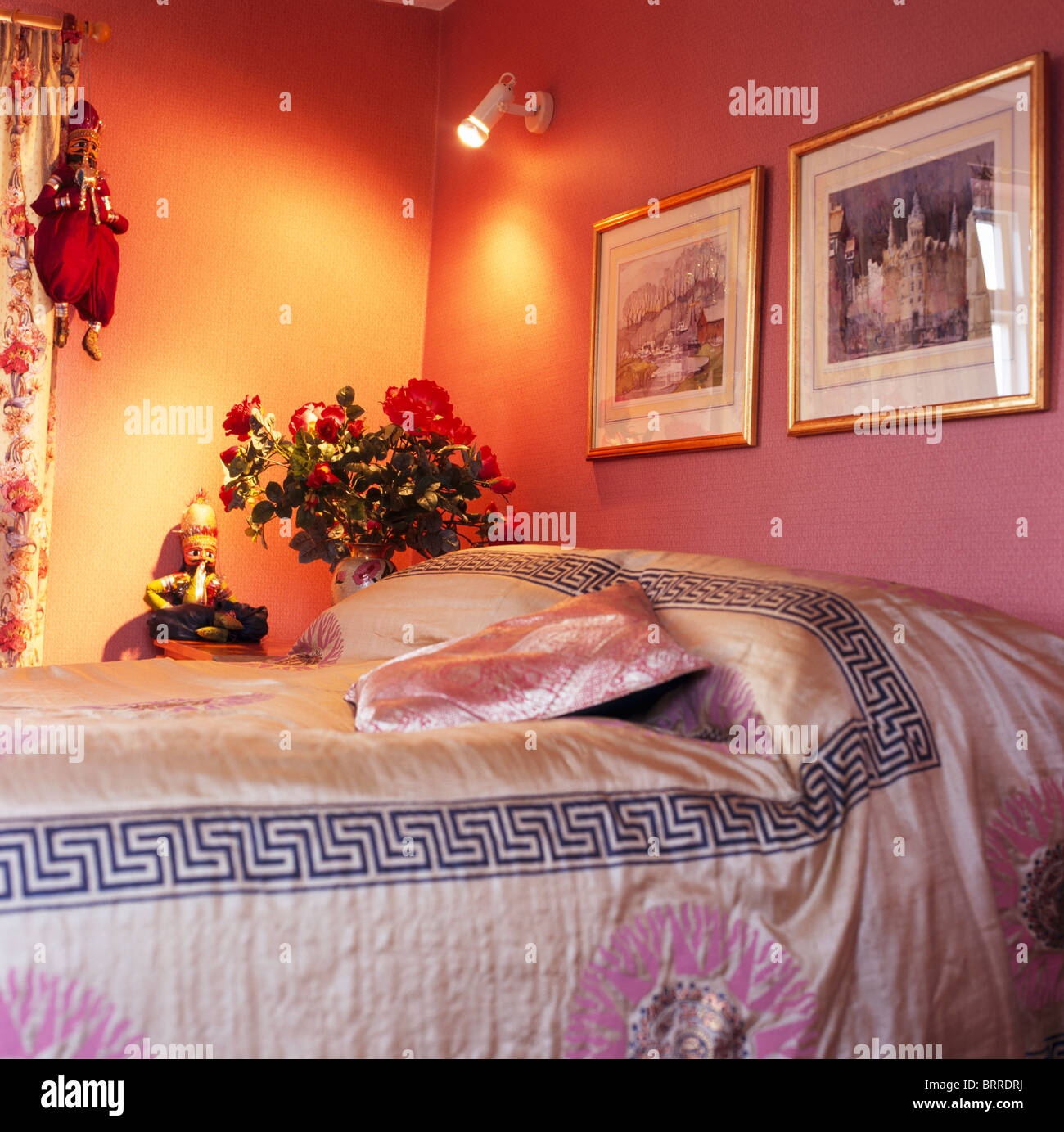 Photos sur mur au-dessus de lit avec un lit de style chinois en  soie-couverture en chambre rose avec Spotlight sur mur en coin de la  chambre Photo Stock - Alamy