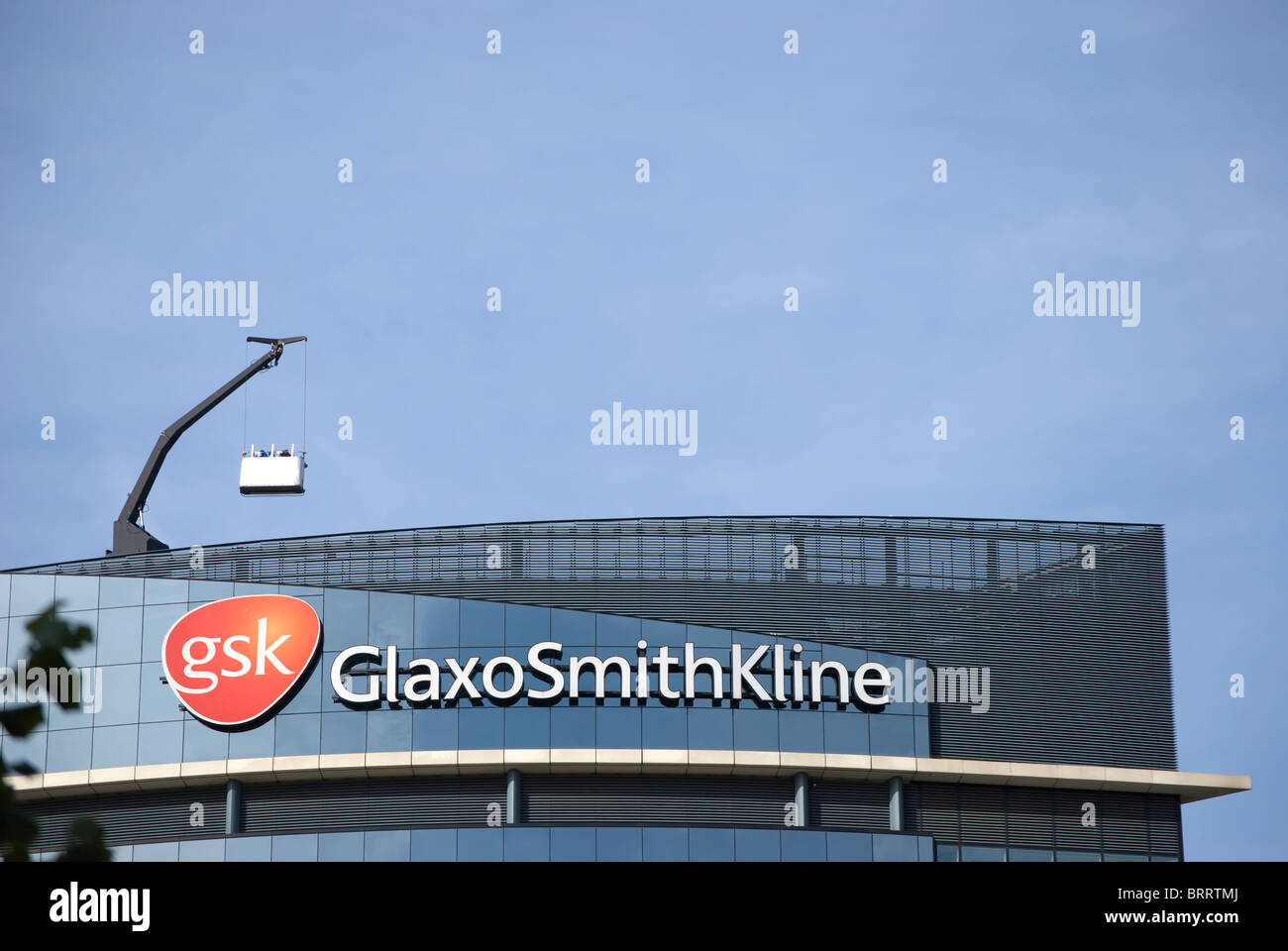 Siège mondial de l'entreprise pharmaceutique gsk, ou Glaxo Smith Kline, montrant l'emblème et crane pour le nettoyage des vitres berceau Banque D'Images