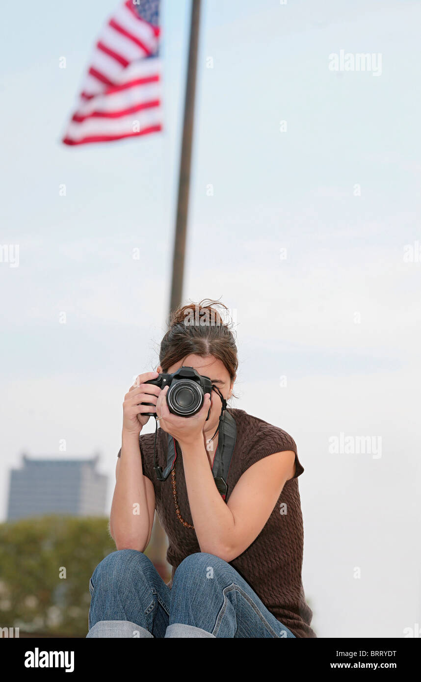 Une brunette woman taking photos avec appareil photo professionnel dans la ville Banque D'Images