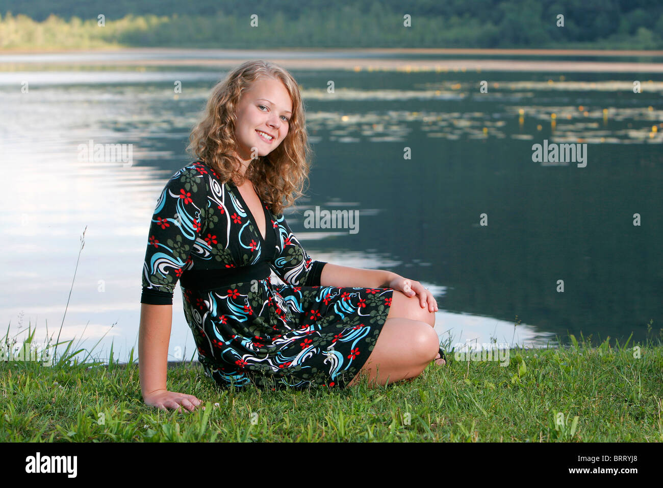 Une jeune teen blonde model posing outdoors pour un portrait assis Banque D'Images