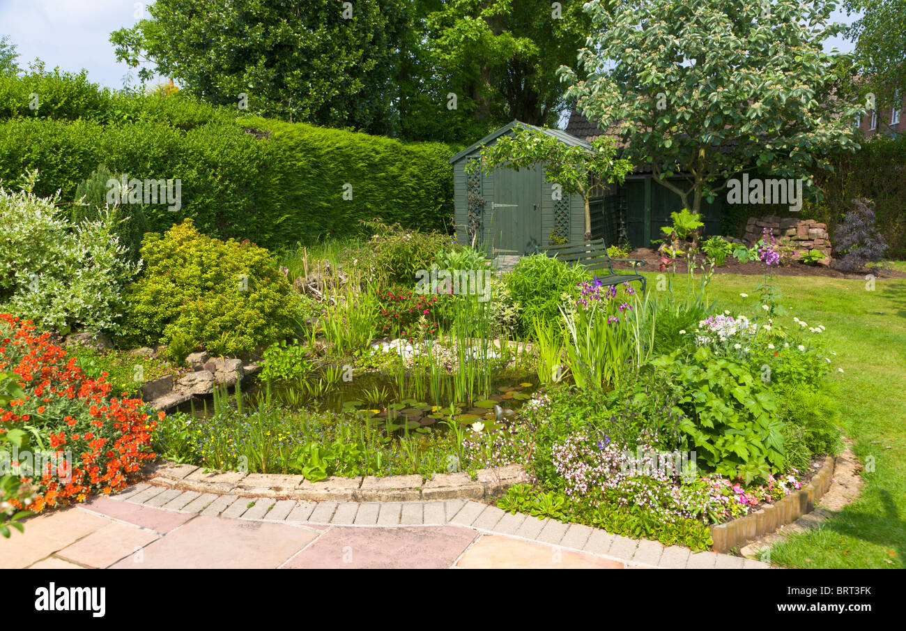 Jardin avec étang et abri de jardin, Wirral, Merseyside, Angleterre Banque D'Images